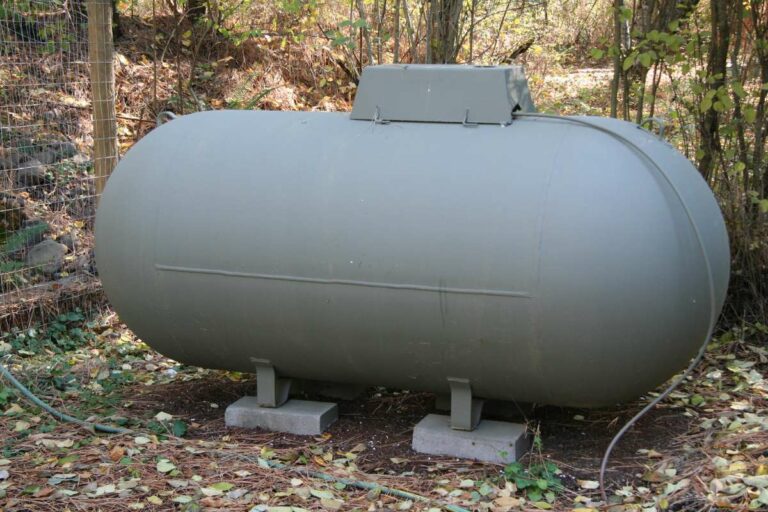 Citerne à mazout grise avec jauge connectée dans un jardin